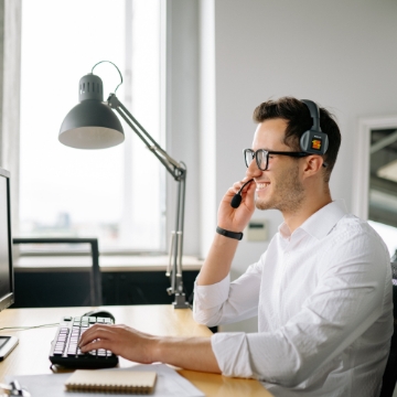 Smiling sales representative making a call on headset