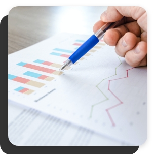 Hand with pen outlining bar and line graphs trending upward