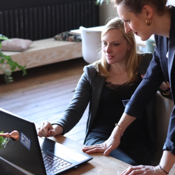 Sales leader and sales rep going through reports on computer